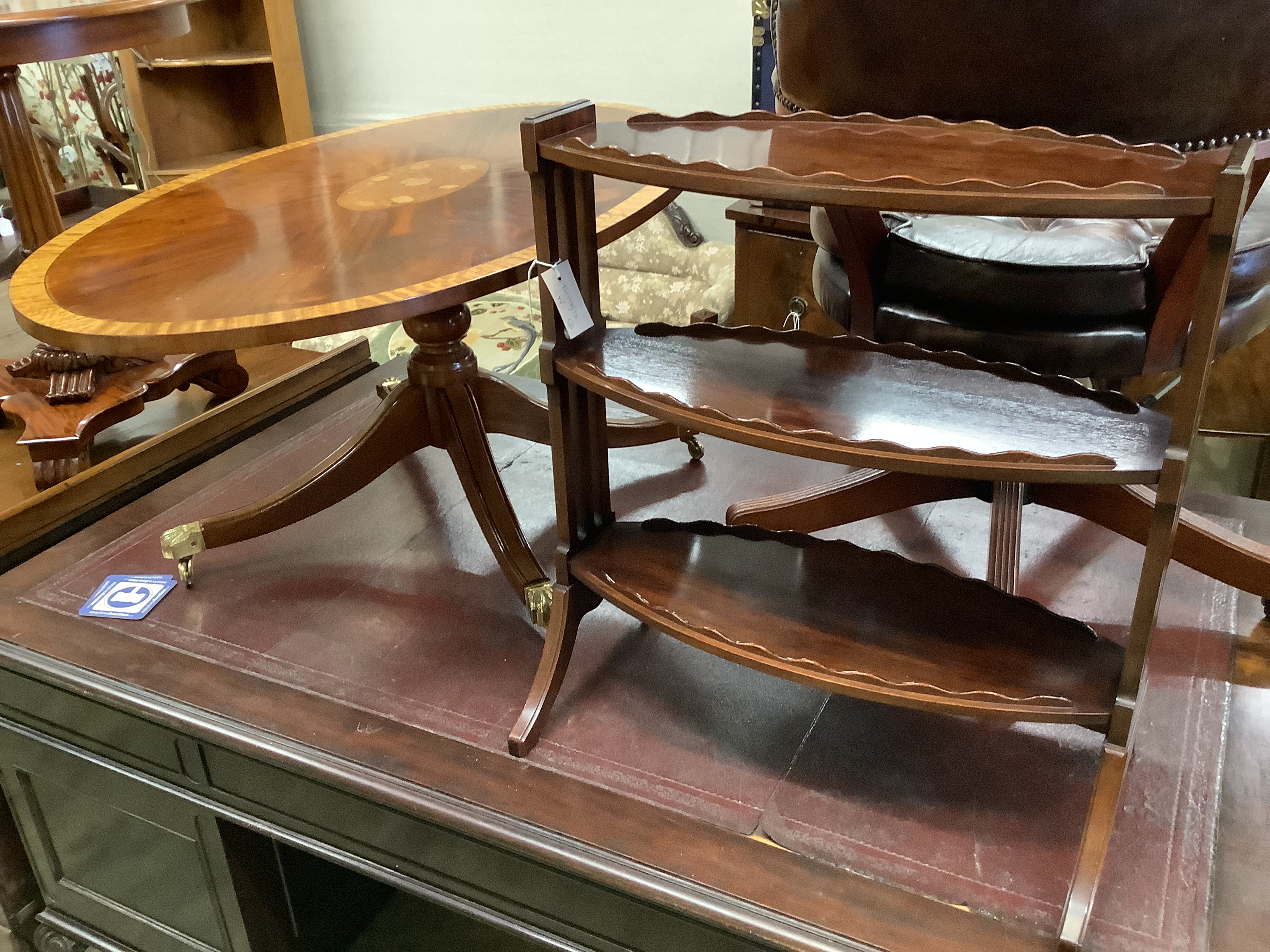 A reproduction low oval mahogany coffee table, length 120cm, depth 68cm, height 50cm together with an oval mahogany three-tier occasional table